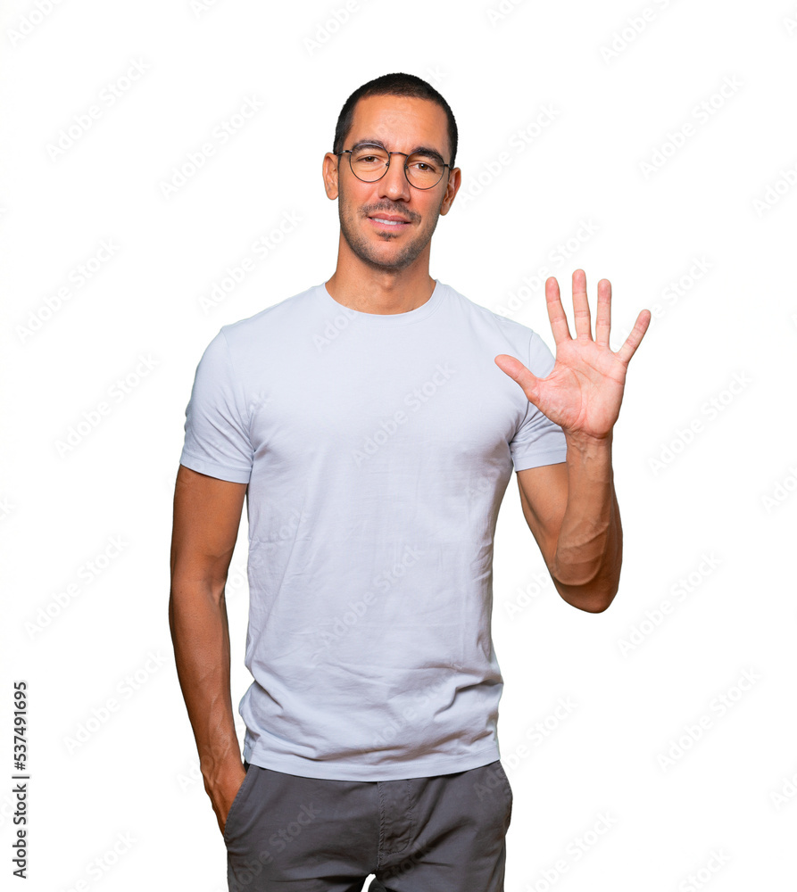 Young man making a number five gesture Young man making a number five gesture