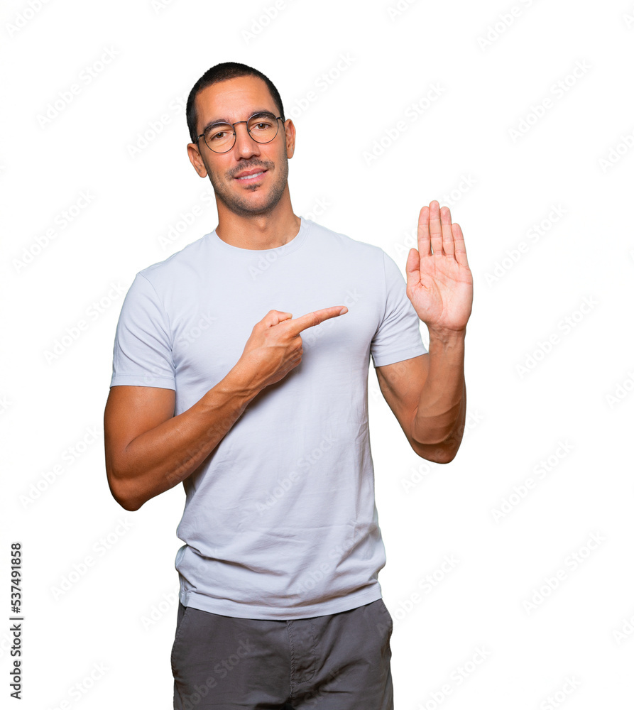 Happy young man making a gesture of stop with his palm Happy young man making a gesture of stop with his palm