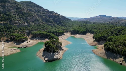 This clip of one of the beautiful Andalusian lakes shows how global warming has caused the water levels on our planet to receed. The normal level of the reservoir is clearly shown below the tree line. photo