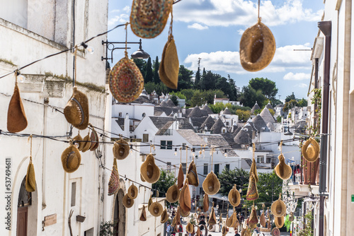 narrow cobblestone streets and round stone trulli houses in Arbelobello. Stone pointed roofs and brick stone whitewashed houses on a sunny day