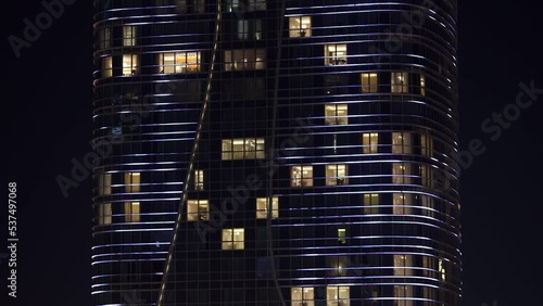 Close-up. Office building with glowing windows against the background of the night sky. Screensaver for a real estate site. Business center in Uzbekistan.