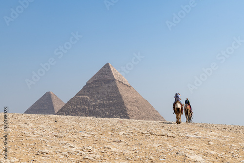 Pyramiden von Gizeh bei Kairo, Kamele mit Reisenden, Ansicht von hinten.