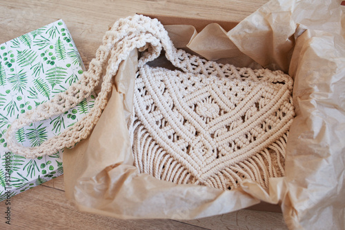 Handmade macrame cotton сross-body bag in the box. Eco bag for women from cotton rope. Scandinavian style bag. Beige tones color, sustainable fashion accessories. Details. Close up image