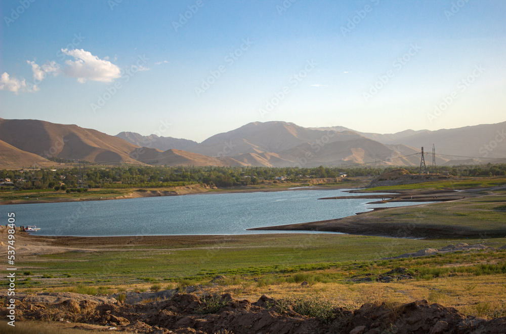 Grass pasture with lake and background mountains