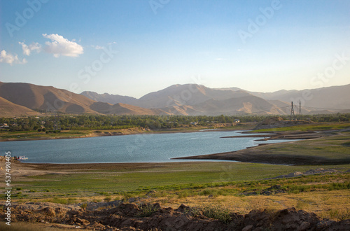 Grass pasture with lake and background mountains