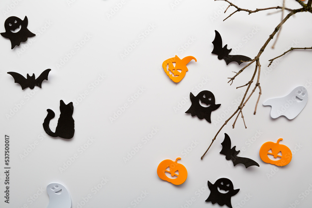 Halloween holiday decoration pumpkin ghost branches on light surface copy space