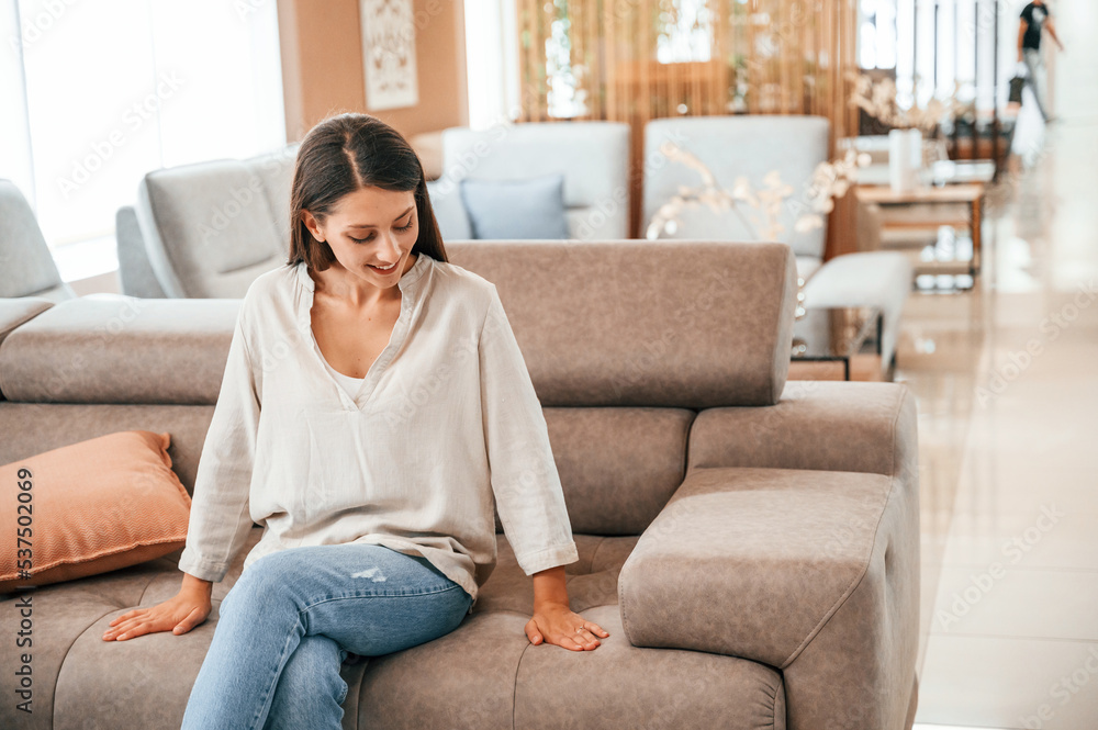 Sitting and relaxing. Woman is visiting bed store. Looking for comfortable sofa Sitting and relaxing. Woman is visiting bed store. Looking for comfortable sofa