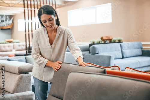 Free Download Touching the smooth surface. Woman is visiting bed store. Looking for comfortable sofa - GFXLoad