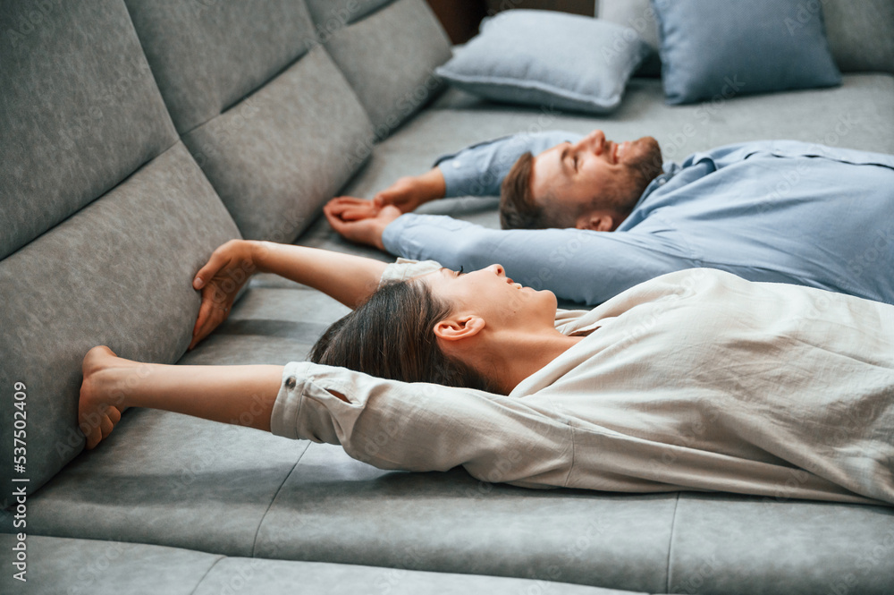 Laying down together. Couple choosing the sofa and bed in the store Laying down together. Couple choosing the sofa and bed in the store