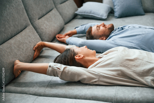 Laying down together. Couple choosing the sofa and bed in the store