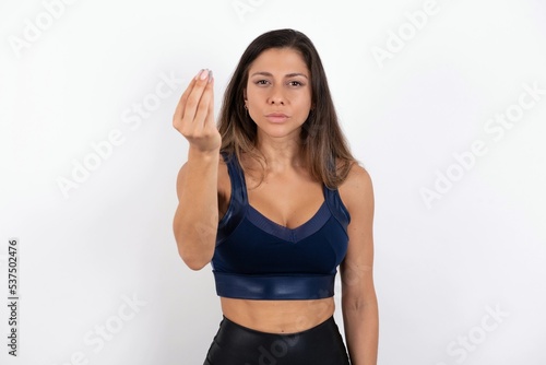 young beautiful woman wearing sportswear over white background Doing Italian gesture with hand and fingers confident expression © Jihan