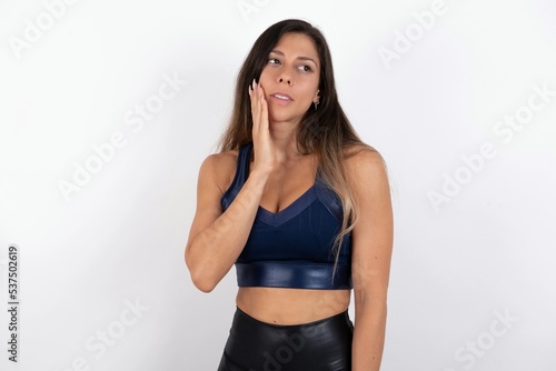 Photo of young beautiful woman wearing sportswear over white background enjoy fresh perfect smooth skin touch face