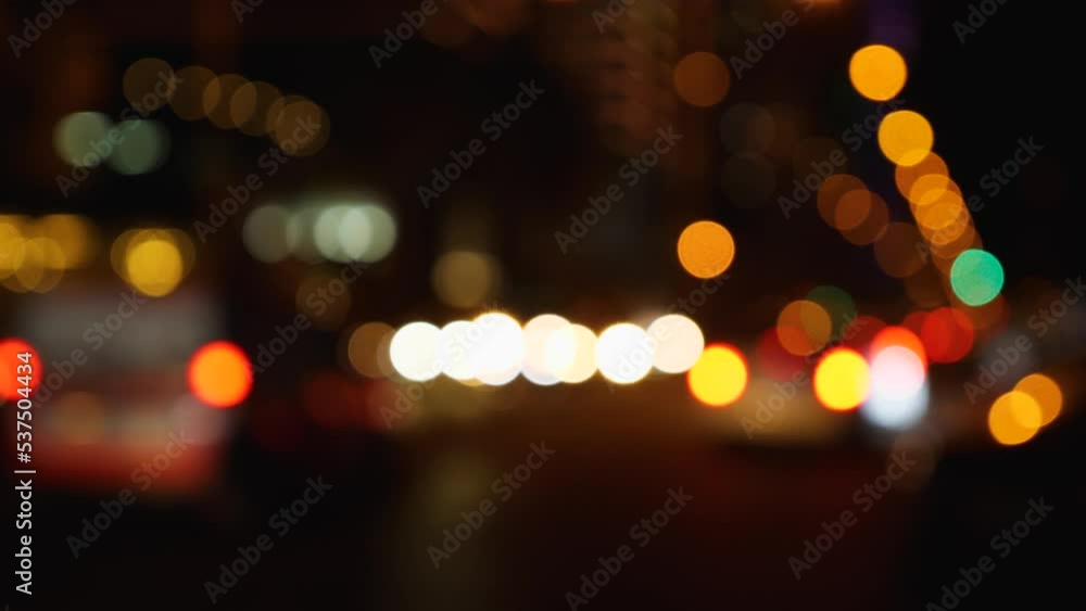 Defocused lights of the city at night. Abstraction. Blurry cars driving through the city. Lights from headlights, streetlights and clearance lights. Blurred background. Slow motion Defocused lights of the city at night. Abstraction. Blurry cars driving through the city. Lights from headlights, streetlights and clearance lights. Blurred background. Slow motion