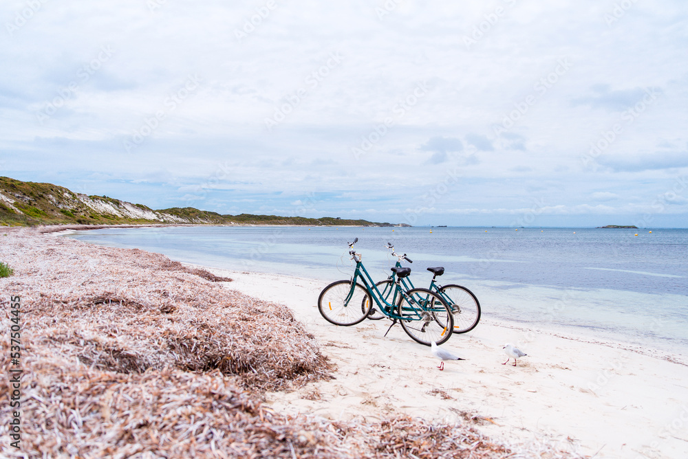 Fototapeta premium Two bicycles parked on a beach on Rottnest Island, Western Australia. Bike rental for tourists. Scenic view