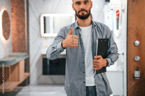 Manager with notepad. Stylish beautiul man is in the store of goods for the home