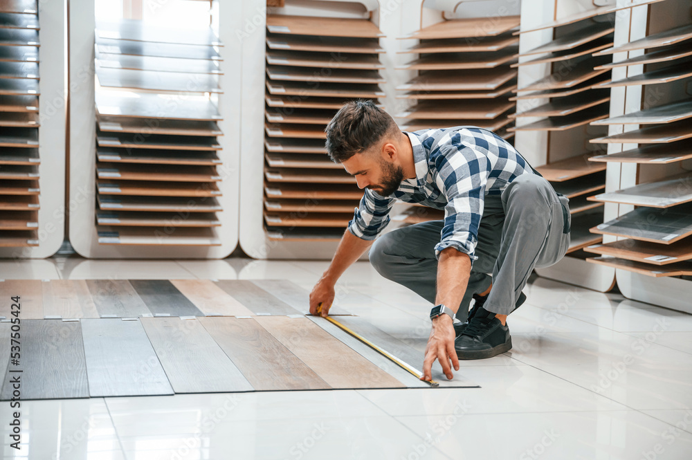 Man in grey uniform is with parquet indoors Man in grey uniform is with parquet indoors