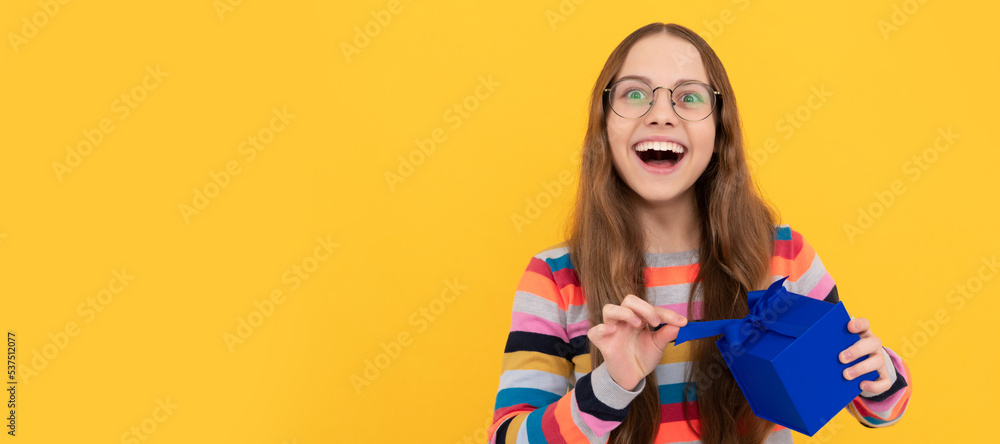 happy teen girl in eyeglasses opening gift box for birthday. Teenager girl with birthday gift, horizontal poster. happy teen girl in eyeglasses opening gift box for birthday. Teenager girl with birthday gift, horizontal poster.