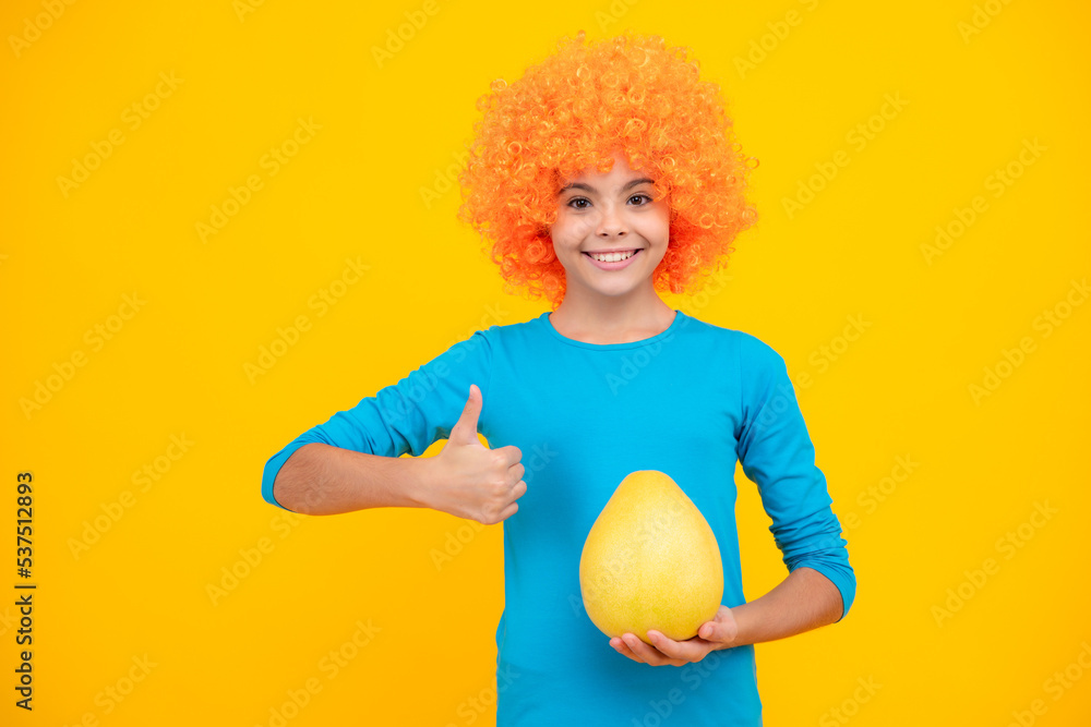 Funny teenage girl hold citrus fruit pummelo or pomelo, big grapefruit isolated on yellow background. Summer fruits. Happy teenager portrait. Smiling girl. Funny teenage girl hold citrus fruit pummelo or pomelo, big grapefruit isolated on yellow background. Summer fruits. Happy teenager portrait. Smiling girl.