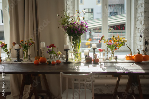 Variety of flowers in a vase on a wooden table in a vintage style room 