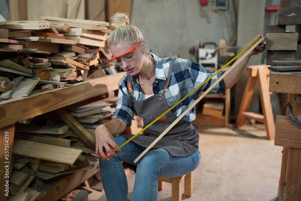 Contemporary Carpenter Working, Portrait of modern carpenter making wood furniture while working in joinery lit by sunlight with factory background on small business concept, copy space Contemporary Carpenter Working, Portrait of modern carpenter making wood furniture while working in joinery lit by sunlight with factory background on small business concept, copy space