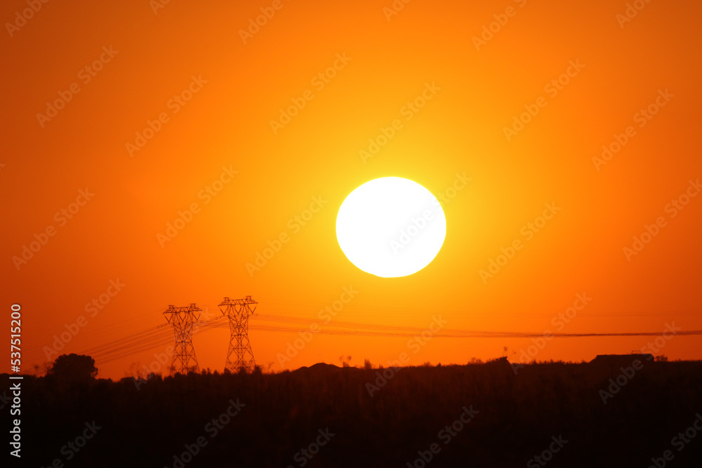 Large, round setting sun with electric pylons, South Africa