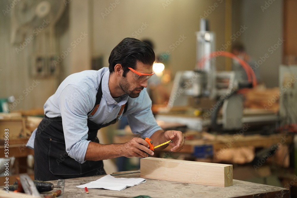 Contemporary Carpenter Working, Portrait of modern carpenter making wood furniture while working in joinery lit by sunlight with factory background on small business concept, copy space