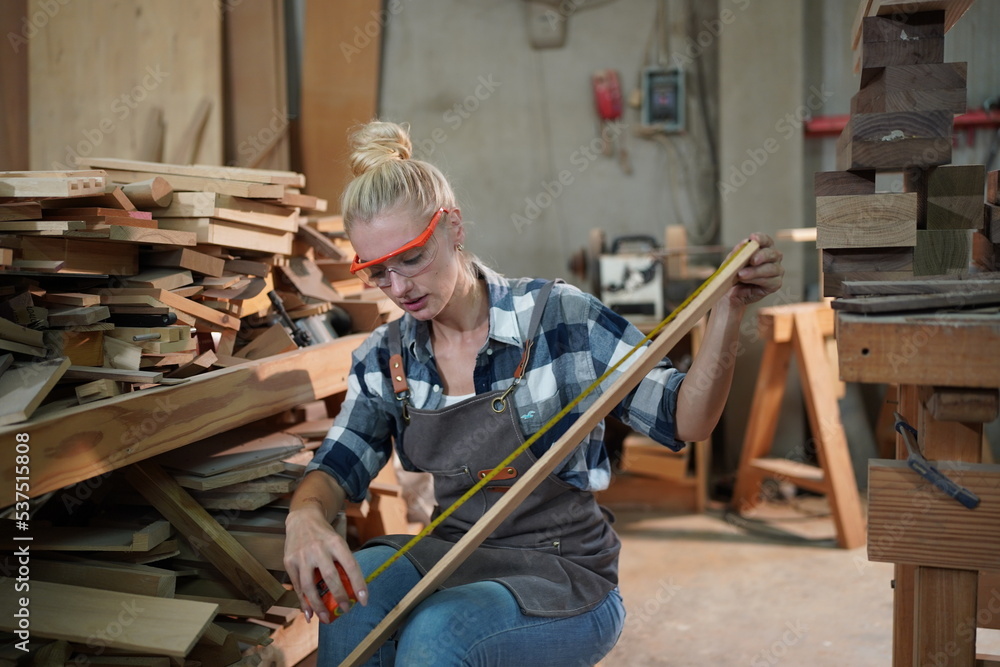 Contemporary Carpenter Working, Portrait of modern carpenter making wood furniture while working in joinery lit by sunlight with factory background on small business concept, copy space Contemporary Carpenter Working, Portrait of modern carpenter making wood furniture while working in joinery lit by sunlight with factory background on small business concept, copy space