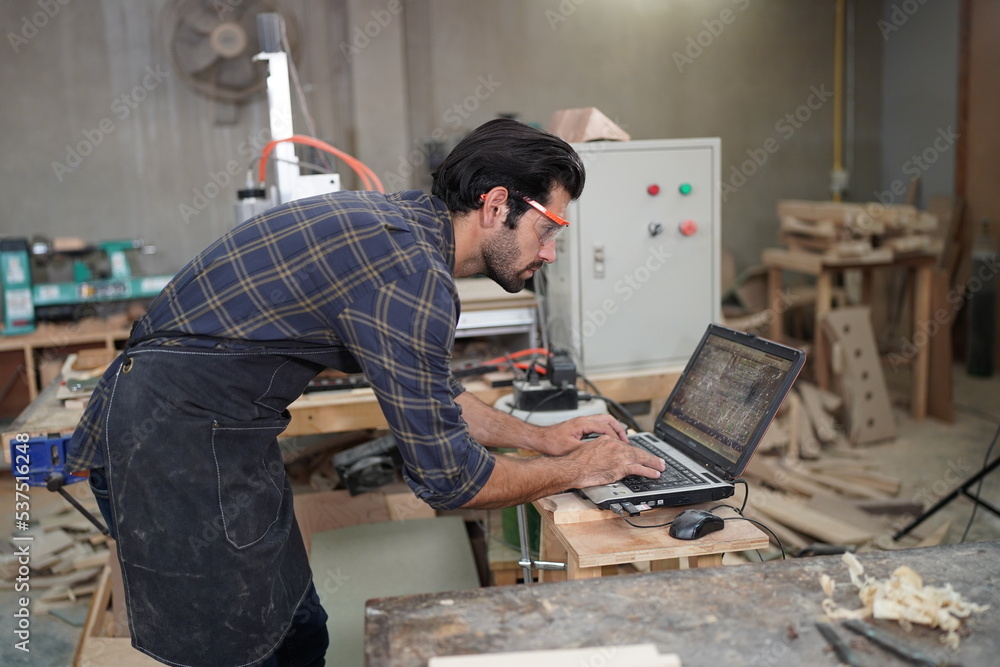 Contemporary Carpenter Working, Portrait of modern carpenter making wood furniture while working in joinery lit by sunlight with factory background on small business concept, copy space Contemporary Carpenter Working, Portrait of modern carpenter making wood furniture while working in joinery lit by sunlight with factory background on small business concept, copy space