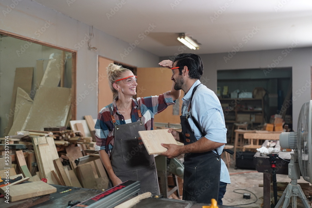 Contemporary Carpenter Working, Portrait of modern carpenter making wood furniture while working in joinery lit by sunlight with factory background on small business concept, copy space Contemporary Carpenter Working, Portrait of modern carpenter making wood furniture while working in joinery lit by sunlight with factory background on small business concept, copy space