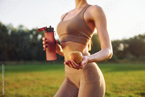 Beautiful nature. Young woman in yoga clothes is outdoors on the field