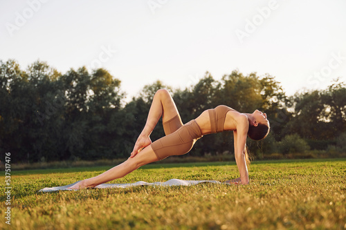 Fitness day. Young woman in yoga clothes is outdoors on the field