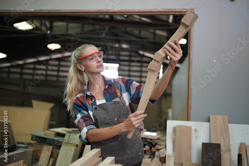 Contemporary Carpenter Working, Portrait of modern carpenter making wood furniture while working in joinery lit by sunlight with factory background on small business concept, copy space