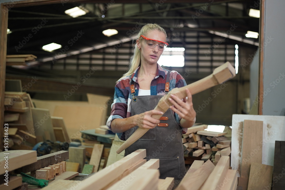Contemporary Carpenter Working, Portrait of modern carpenter making wood furniture while working in joinery lit by sunlight with factory background on small business concept, copy space Contemporary Carpenter Working, Portrait of modern carpenter making wood furniture while working in joinery lit by sunlight with factory background on small business concept, copy space