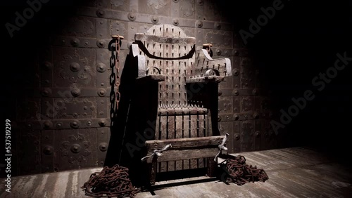 A close-up view of the torture chair and chains used in a medieval torture chamber.