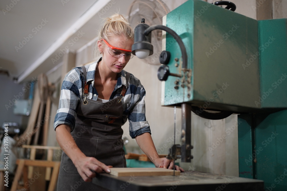 Contemporary Carpenter Working, Portrait of modern carpenter making wood furniture while working in joinery lit by sunlight with factory background on small business concept, copy space Contemporary Carpenter Working, Portrait of modern carpenter making wood furniture while working in joinery lit by sunlight with factory background on small business concept, copy space