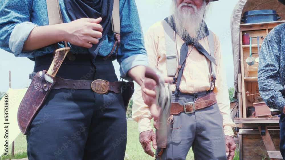 Slow motion of Man cowboy wielding gun Carry and store into the gun holster at the waist in vintage cowboys village background. Cowboy 1800's Concept Slow motion of Man cowboy wielding gun Carry and store into the gun holster at the waist in vintage cowboys village background. Cowboy 1800's Concept