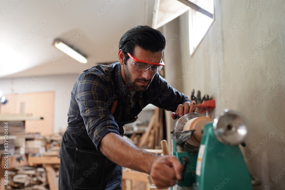 Contemporary Carpenter Working, Portrait of modern carpenter making wood furniture while working in joinery lit by sunlight with factory background on small business concept, copy space Contemporary Carpenter Working, Portrait of modern carpenter making wood furniture while working in joinery lit by sunlight with factory background on small business concept, copy space