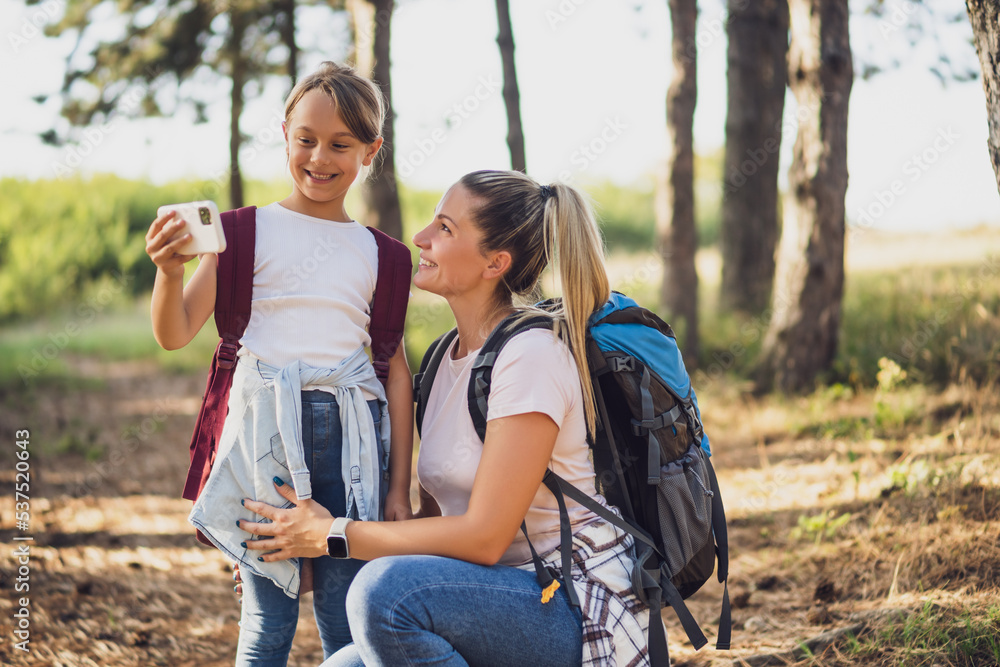 Fototapeta premium Mother and daughter are taking selfie while enjoy hiking. 