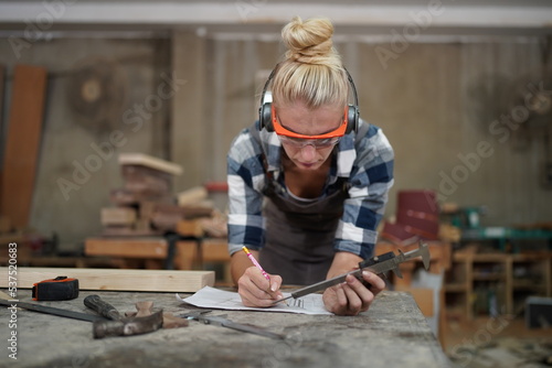 Contemporary Carpenter Working, Portrait of modern carpenter making wood furniture while working in joinery lit by sunlight with factory background on small business concept, copy space