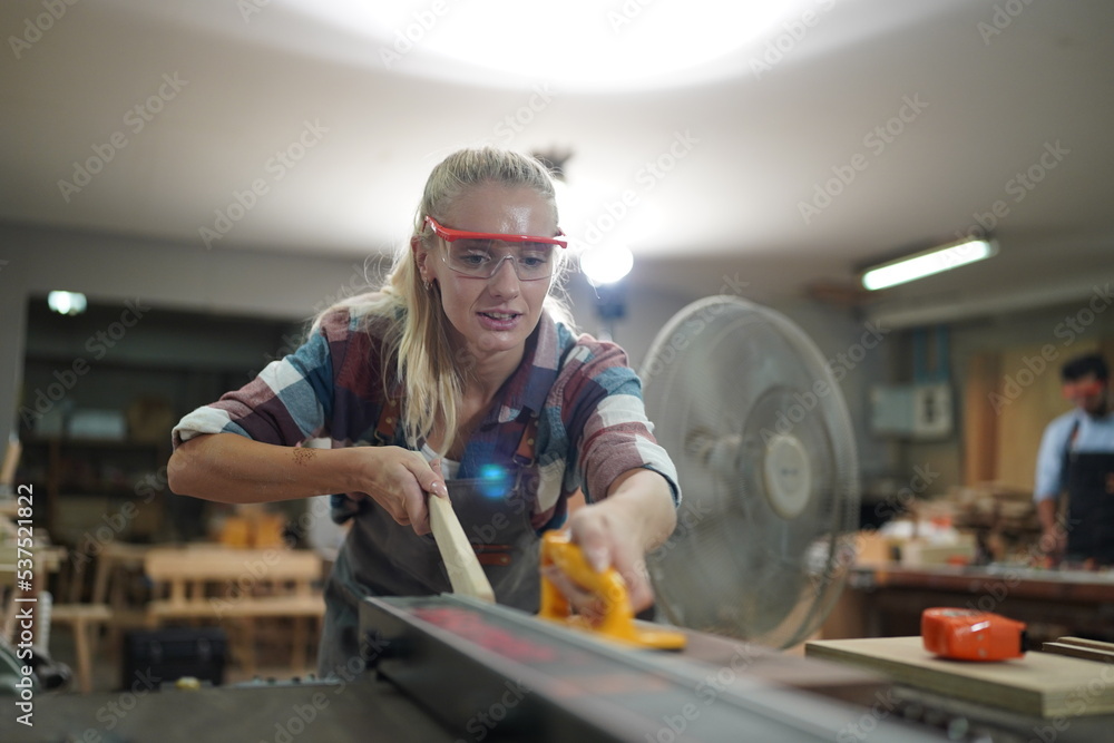 Fototapeta premium Contemporary Carpenter Working, Portrait of modern carpenter making wood furniture while working in joinery lit by sunlight with factory background on small business concept, copy space