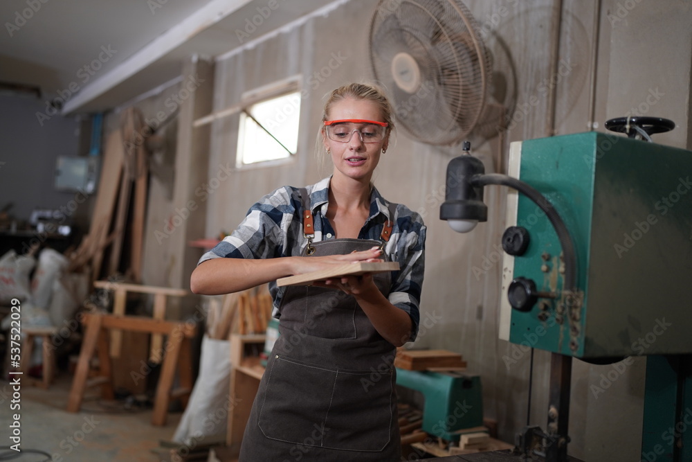 Contemporary Carpenter Working, Portrait of modern carpenter making wood furniture while working in joinery lit by sunlight with factory background on small business concept, copy space