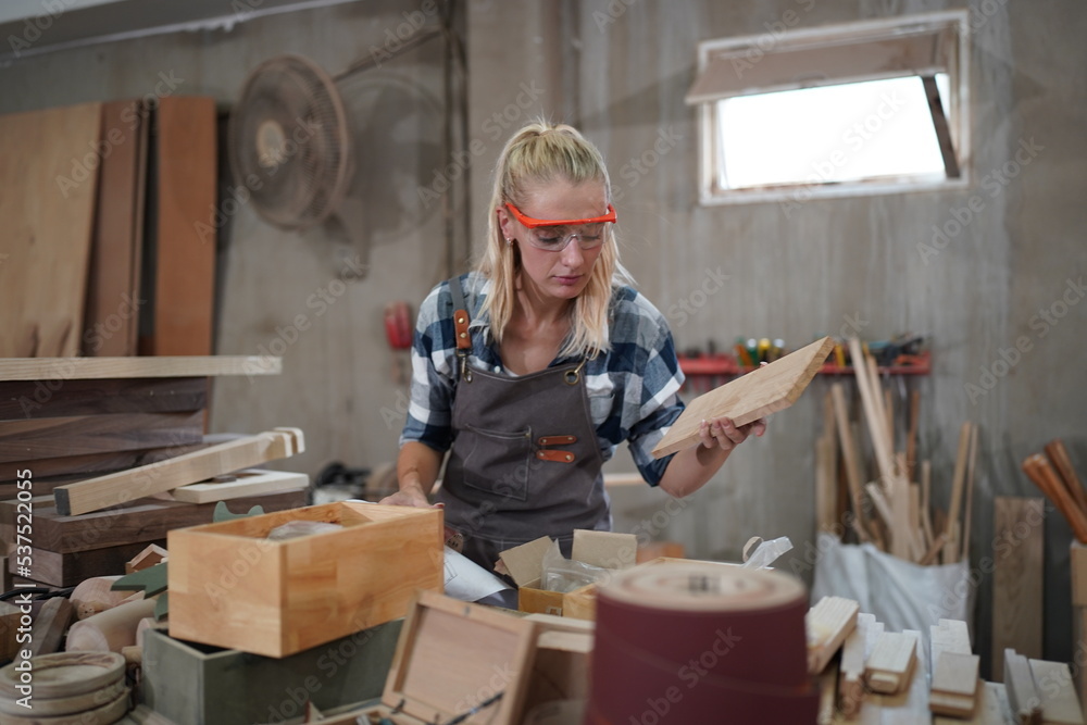 Contemporary Carpenter Working, Portrait of modern carpenter making wood furniture while working in joinery lit by sunlight with factory background on small business concept, copy space Contemporary Carpenter Working, Portrait of modern carpenter making wood furniture while working in joinery lit by sunlight with factory background on small business concept, copy space
