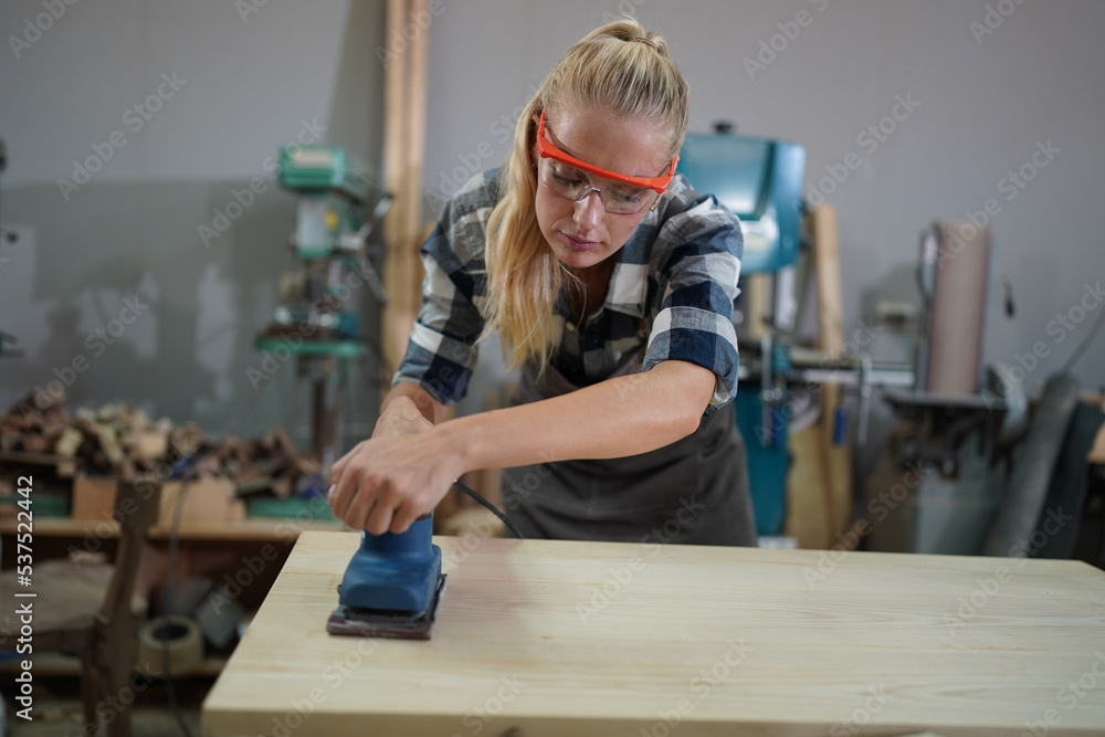 Contemporary Carpenter Working, Portrait of modern carpenter making wood furniture while working in joinery lit by sunlight with factory background on small business concept, copy space Contemporary Carpenter Working, Portrait of modern carpenter making wood furniture while working in joinery lit by sunlight with factory background on small business concept, copy space