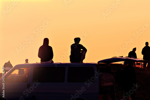 silhouettes of people under a yellow sky