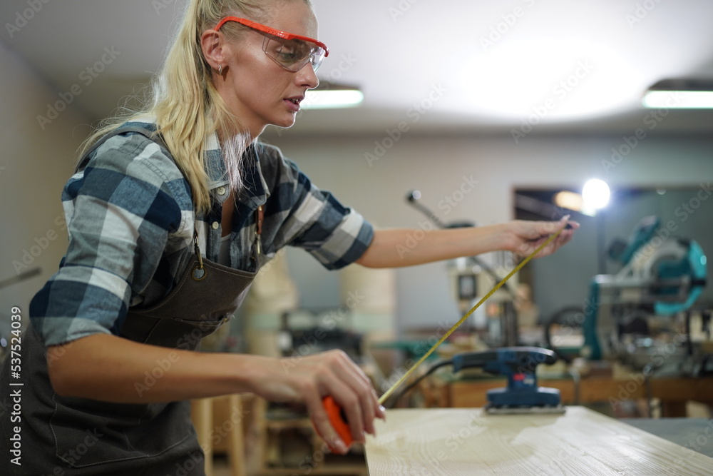 Contemporary Carpenter Working, Portrait of modern carpenter making wood furniture while working in joinery lit by sunlight with factory background on small business concept, copy space Contemporary Carpenter Working, Portrait of modern carpenter making wood furniture while working in joinery lit by sunlight with factory background on small business concept, copy space