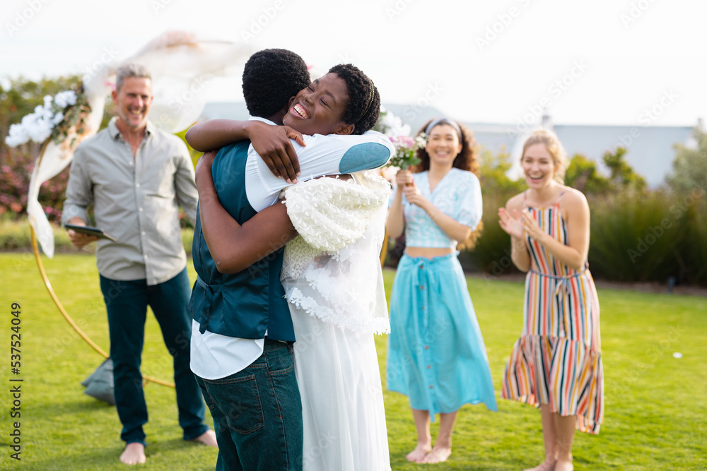Happy african american couple embracing with caucasian friends during wedding Happy african american couple embracing with caucasian friends during wedding