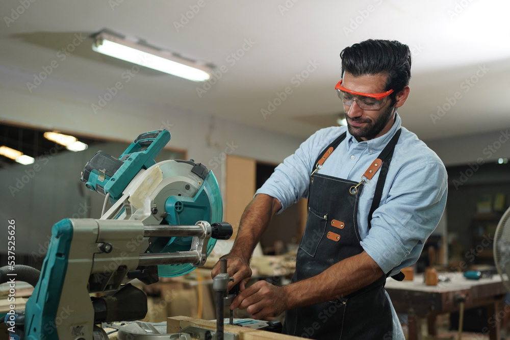 Contemporary Carpenter Working, Portrait of modern carpenter making wood furniture while working in joinery lit by sunlight with factory background on small business concept, copy space