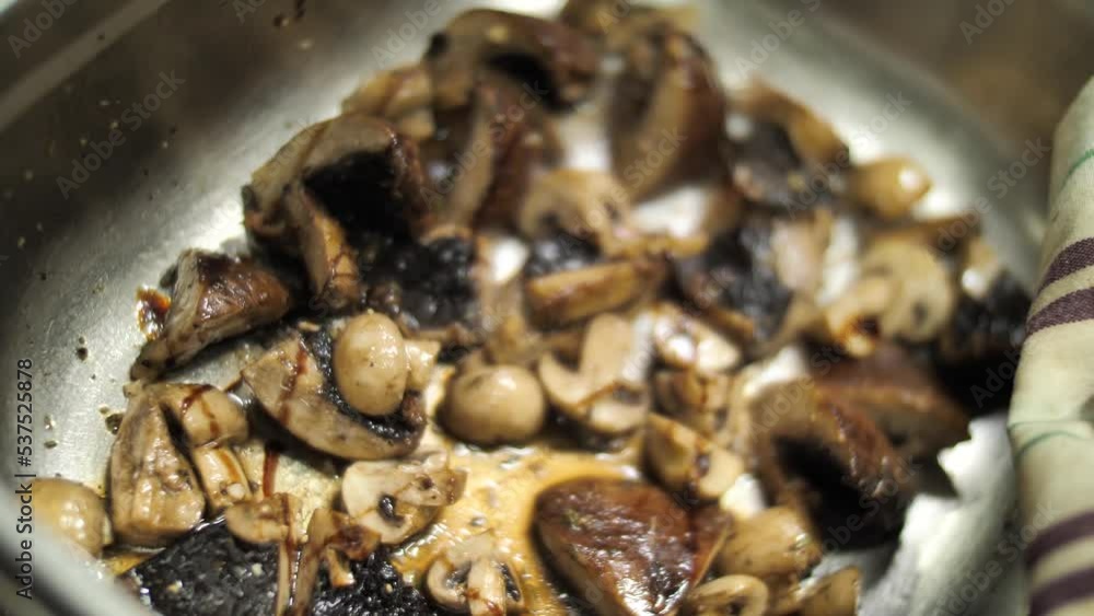 Adding soy sauce to fried champignon mushrooms in saucepan, close up Adding soy sauce to fried champignon mushrooms in saucepan, close up