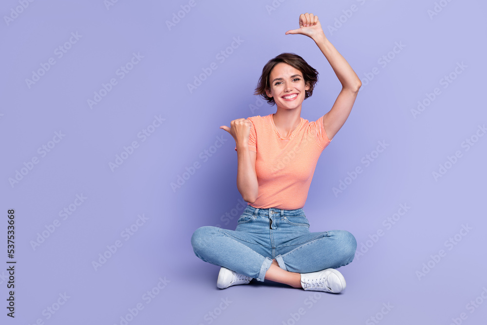 Full length photo of funny cheerful lady wear striped t-shirt pointing two thumbs empty space isolated violet color background Full length photo of funny cheerful lady wear striped t-shirt pointing two thumbs empty space isolated violet color background
