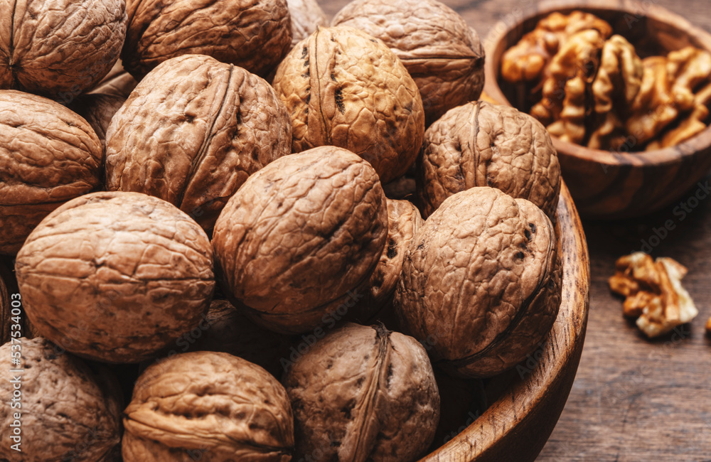 Fresh raw walnuts, autumn food background, nuts harvest. Old rustic wooden background, top view, close up Fresh raw walnuts, autumn food background, nuts harvest. Old rustic wooden background, top view, close up